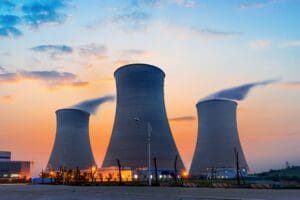 3 nuclear cooling towers with a sunset background